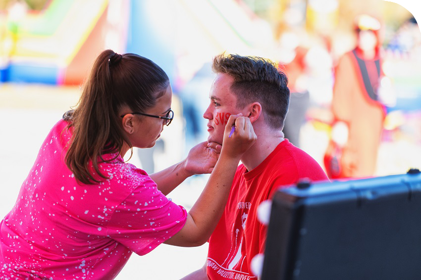 alumni getting their face painted at homecoming